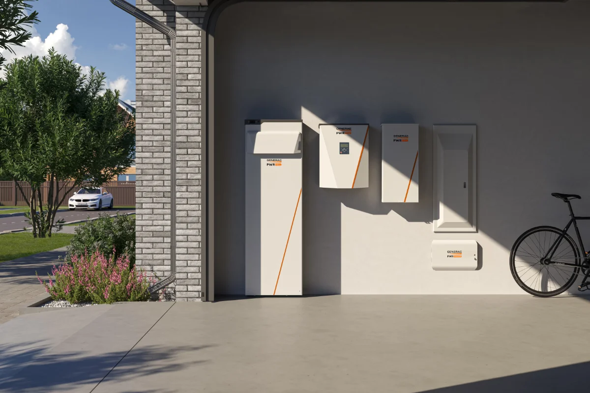 A modern garage with four wall-mounted energy storage units, a parked bicycle, and a view of a driveway with greenery and a white car outside.